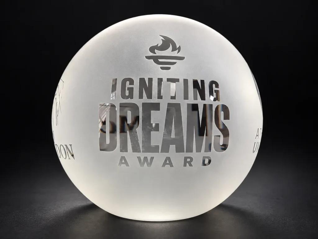 Frosted crystal ball engraved with the Igniting Dreams Award torch logo